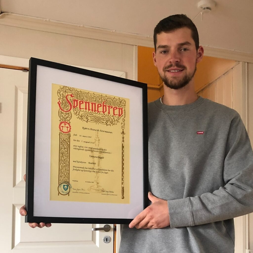 Bjørn Henrik proudly shows off his journeyman's letter which he has framed at home.